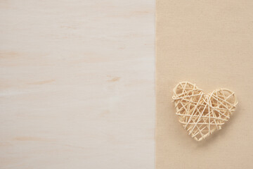 Decorative wicker rattan heart on a wooden background