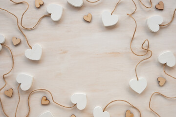 A frame for Valentine&rsquo;s Day composed of various hearts on a wooden background