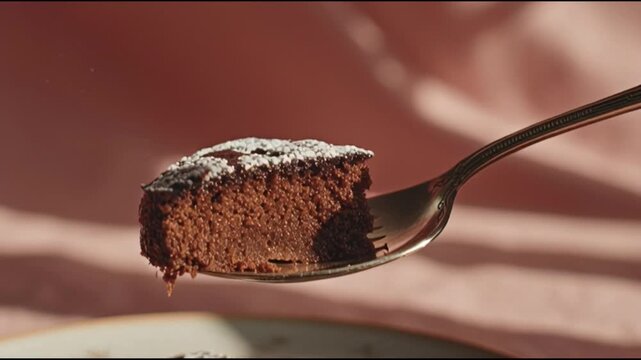 Chocolate cake on a silver spoon.