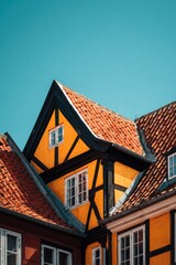 Obraz premium Bright buildings with colorful paint and unique roof designs in a historical town during a sunny day showcase local architecture
