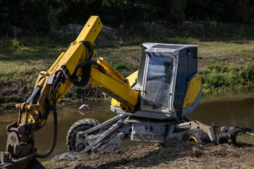 Yellow Industrial Walking Excavator Working in Water Canal