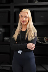 Confident blonde woman IT technician with laptop in a modern tech setting