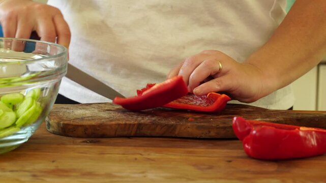 Woman cutting red pepper for salad
