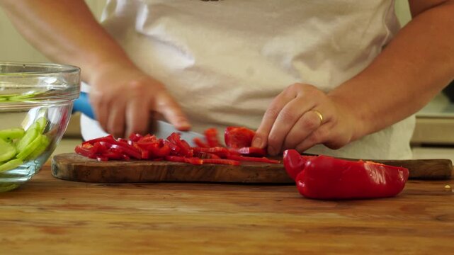 Woman cutting red pepper for salad
