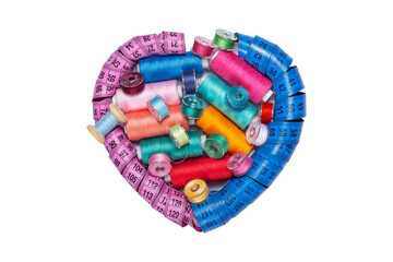 Sewing kit, bobbins with colored threads and a heart-shaped measuring tape.