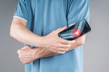Man holding smartphone with digital x-ray of elbow joint showing pain, arthritis and inflammation,...