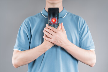 Man holding smartphone with digital scan of thyroid gland showing pain and inflammation,...