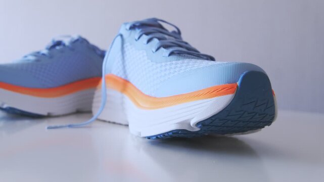 Pair of blue running shoes with orange accents and mesh fabric
