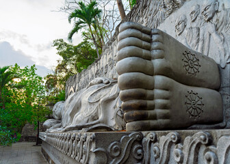 Statue of a reclining Buddha with a view of the heels. Sleeping Buddha. Vietnam, Nha Trang, Long Son Pagoda.