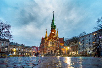 Fototapeta premium St. Joseph's Church in Krakow Podgorze at dusk with wet pavement reflection and evening lights