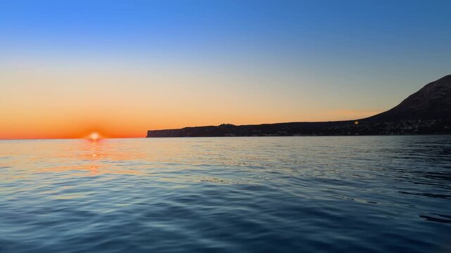 Costa Blanca sunrise over calm Mediterranean sea and coastal horizon