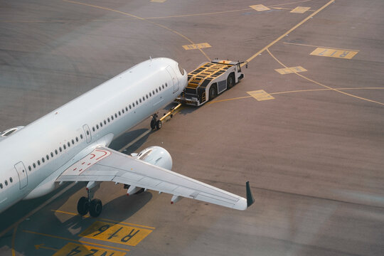 Aircraft departing international apron airport runway. Tow truck push back untitled airplane aerial view plane.