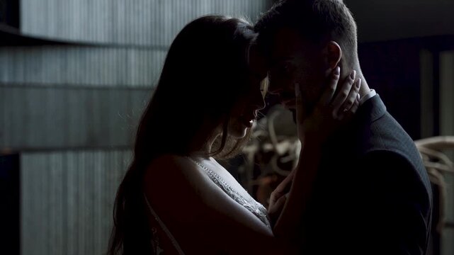 Couple shares a moment in a dimly lit space during a special event in the evening
