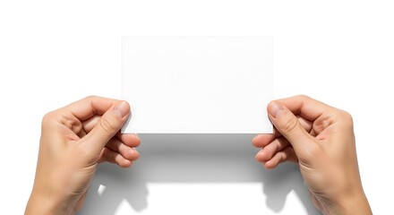 Obraz premium A person's hand is holding an empty business card or a white sheet of paper on a white background