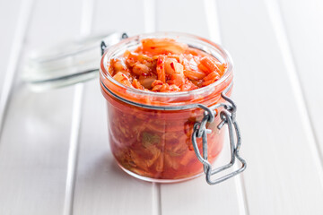 Fermented cabbage. Kimchi. Korean food in jar on white table.