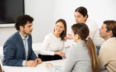 Fototapeta premium Emotional language teacher telling interesting stories to adult attentive students during class break in auditory