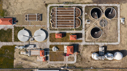 Comprehensive aerial shot of a large water purification facility with various treatment stages, tanks, and buildings in a symmetrical layout. © TAMER YILMAZ