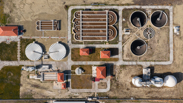 Comprehensive aerial shot of a large water purification facility with various treatment stages, tanks, and buildings in a symmetrical layout.