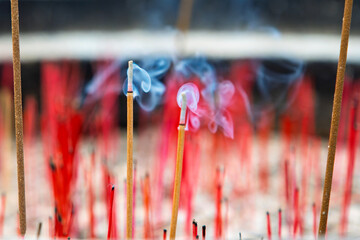 Burning incense sticks in an incense burner, close-up. Incense sticks with smoke in an incense pot.