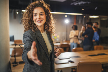 Confident businesswoman offering handshake greeting in office © Miljan Živković