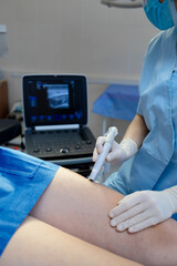 Doctor performing ultrasound scan of leg veins.