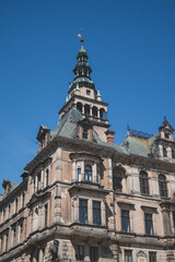 Obraz premium Low angle architectural detail of an ornate Neo-Renaissance corner building in the historic center of Kłodzko. The facade features intricate sculptures, decorative reliefs, and a prominent balcony typ