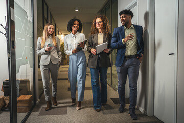 Fototapeta premium Diverse business team walking through office corridor collaborating