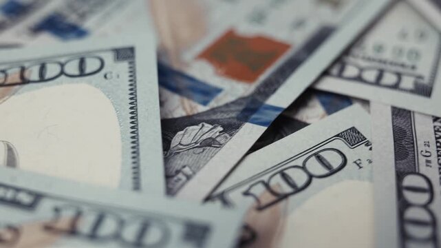 Close-up frames of US dollar banknotes stacked together, showcasing intricate details of design, color, and texture, emphasizing wealth and currency in a visually rich arrangement