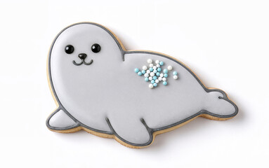 Obraz premium Seal shaped iced cookie on white background decorated with pastel sprinkles, playful animal treat for kids and baking decoration concept