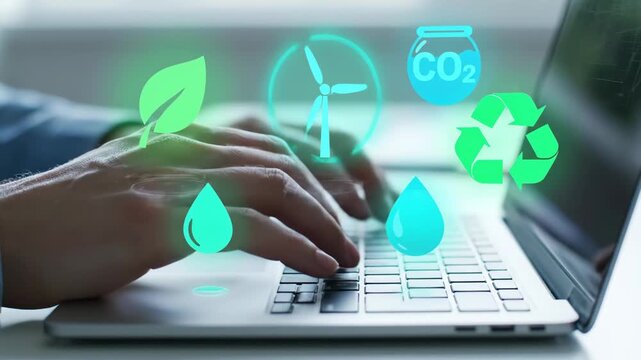 Businessman typing on a laptop with holographic icons representing sustainable energy and environmental conservation concepts.