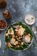 Winter kale salad with apples and pecan served with balsamic vinaigrette dressing