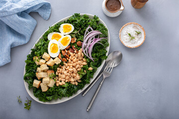 Healthy kale salad with beans, soft boiled eggs and red onion, high protein salad idea
