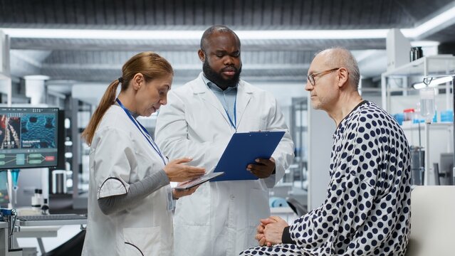 Medical researchers conducting patient evaluation in a laboratory drug study, collecting data on treatment outcomes and side effects, supporting toxicology and immunology research. Camera B.