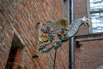 Decorative metal griffin sign on brick wall