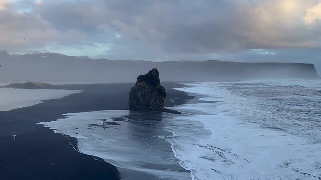 Centered shot of Reynisdrangar basalt sea stacks and Reynisfjara black sand beach from Dyrholaey, Iceland.