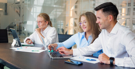 Fototapeta premium Group works on project at modern office with laptops and documents during daytime hours