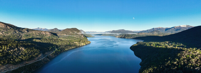 Aerial shot of a large blue lake with morning moon