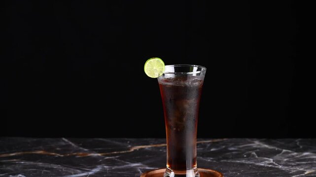 Classic Cuba libre drink with lime garnish and condensation