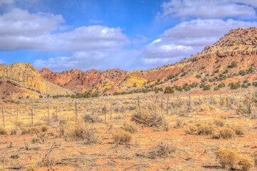 A desert landscape with a fence in the foreground
