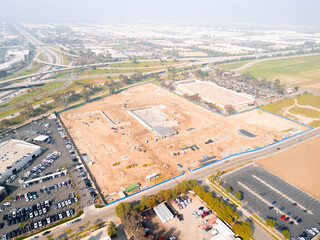 Aerial view of a large-scale construction site with heavy machinery and industrial building progress.ult