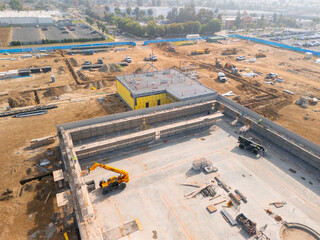 Aerial view of a large-scale construction site with heavy machinery and industrial building progress.ult