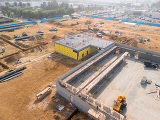 Aerial view of a large-scale construction site with heavy machinery and industrial building progress.ult