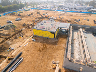 Aerial view of a large-scale construction site with heavy machinery and industrial building progress.ult
