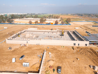 Aerial view of a large-scale construction site with heavy machinery and industrial building progress.ult