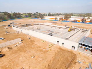 Aerial view of a large-scale construction site with heavy machinery and industrial building progress.ult