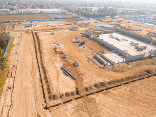 Aerial view of a large-scale construction site with heavy machinery and industrial building progress.ult