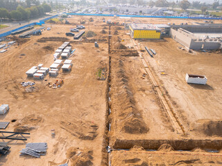 Aerial view of a large-scale construction site with heavy machinery and industrial building progress.ult