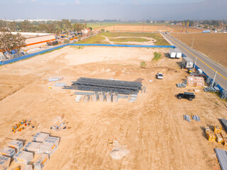 Aerial view of a large-scale construction site with heavy machinery and industrial building progress.ult