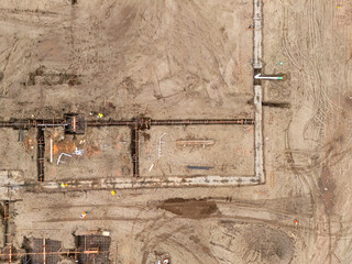 Aerial view of a large-scale construction site with heavy machinery and industrial building progress.ult