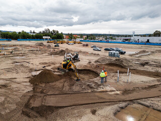 Aerial view of a large-scale construction site with heavy machinery and industrial building progress.ult